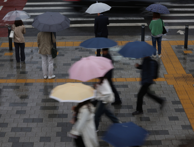 4일 오전 서울 중구 서울시청 인근에서 시민들이 우산을 쓴 채 이동하고 있다. 연합뉴스