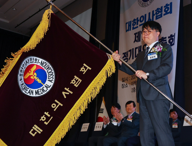 임현택 대한의사협회 회장이 지난달 28일 서울 서초구 더케이호텔에서 열린 정기대의원총회에서 협회기를 건네받은 뒤 흔들고 있다. 연합뉴스