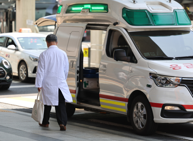 5월 3일 서울 시내 한 대형병원에서 한 의료진이 구급차 앞을 지나고 있다. 연합뉴스