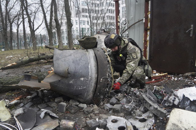 우크라이나의 한 경찰관이 지난 1월 2일 하르키우에 떨어진 미사일 잔해를 조사하고 있다. AP연합뉴스