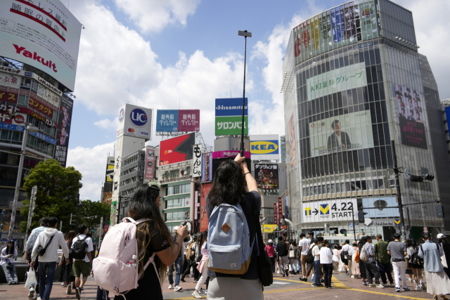 엔화 가치 약세로 해외에서 일본을 찾는 관광객이 증가하는 가운데 싸고 품질 좋은 중고 명품을 구매하려는 수요도 늘고 있다. 사진은 일본의 대표적인 관광지인 도쿄 시부야 스크램블에서 사진을 찍는 외국인./EPA연합뉴스
