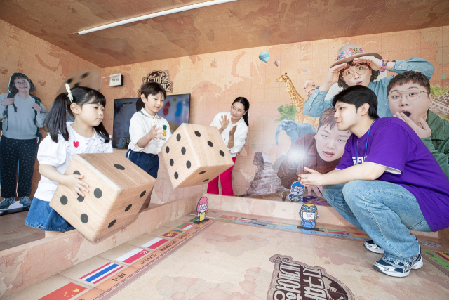 시민들이 KT가 서울시와 제휴해 광화문광장 육조마당에 연 '지니 TV 팝업'에서 ENA 채널 '지구마블 세계여행2' 콘텐츠로 만든 게임을 즐기고 있다. 사진 제공=KT