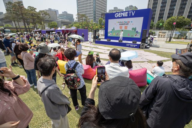 시민들이 KT가 광화문광장 육조마당에 연 '지니 TV 팝업'에서 시네마 콘서트를 감상하고 있다. 사진 제공=KT