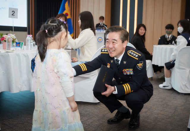 윤희근 경찰청장이 8일 진행된 100원의 기적 모금 수여장 전달식에서 순직 경찰관의 자녀에게 인사를 하고 있다. 사진제공=경찰청