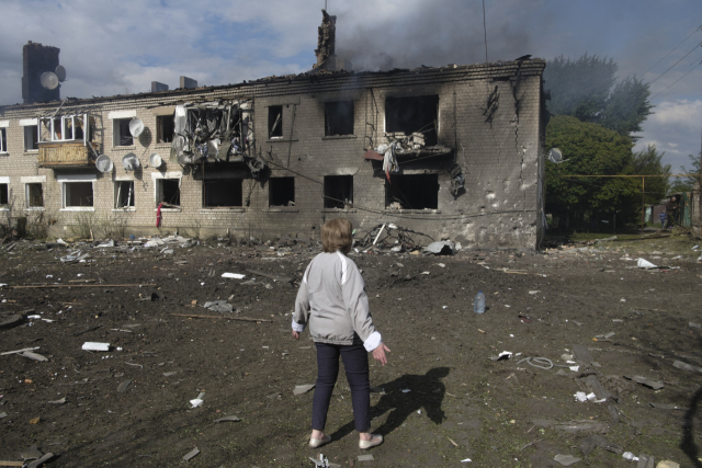우크라이나 시민이 11일 우크라이나 하르키우 지역의 볼찬스 외곽에서 최근 포격 당시 손상된 건물을 바라보고 있다. 이날 러시아의 침공으로 1700명 이상이 하르키우 국경 지역에서 대피했다.EPA연합뉴스