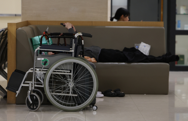 12일 서울 한 대형병원에서 한 환자가 휠체어에서 내려 휴식을 취하고 있다. 연합뉴스
