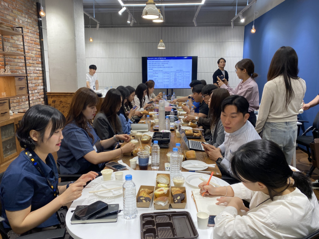 MD서포터즈들이 9일 서울 강남구 GS리테일 본사에서 열린 품평회에 참석해 곧 출시 예정인 신상품을 먹어본 뒤 솔직한 의견을 전달하고 있다. 김남명 기자