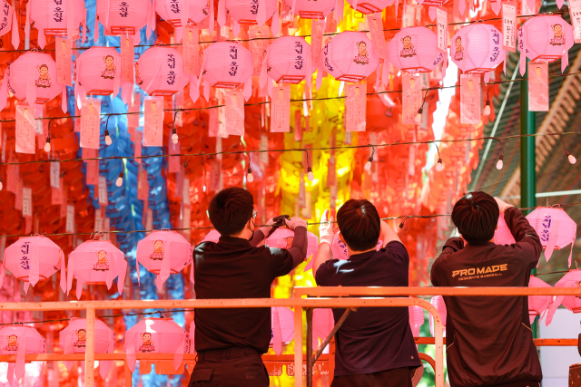 부처님 오신 날을 하루 앞둔 14일 오후 서울 종로구 조계사에서 관계자들이 연등을 매달고 있다. 연합뉴스