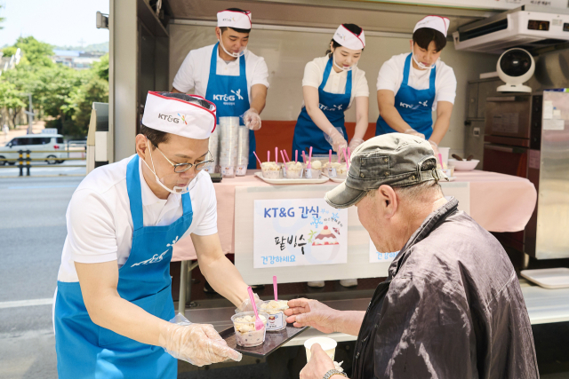 14일 서울역 인근 시립 무료급식소인 ‘따스한채움터’에서 방경만 KT&G 사장이 간식을 전달하고 있다. 사진 제공=KT&G