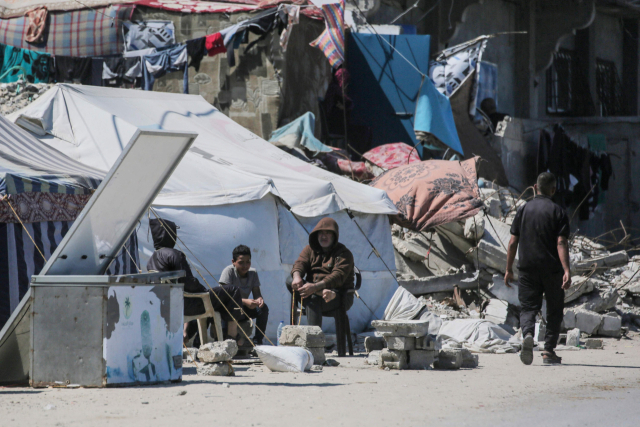 15일(현지 시간) 가자지구 중부 지역에 있는 난민 수용소에 사람들이 앉아 있다. AFP연합뉴스