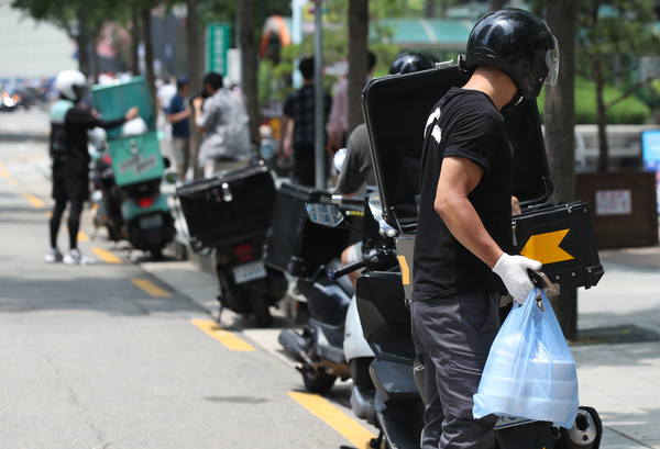 서울 종로구의 한 골목에서 배달 대행업체 라이더들이 음식을 배달하고 있다. 연합뉴스