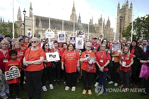 19일(현지시간) 공식 조사위원회 보고서를 하루 앞두고 영국 런던 웨스트민스터 의사당 앞에서 진상 규명을 촉구하는 시위대가 모여 있다. AP 연합뉴스