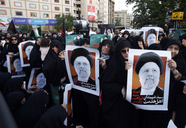 20일(현지시간) 헬기 추락 사고로 숨진 에브라힘 라이시 이란 대통령 애도식이 열린 테헤란에서 여성들이 라이시 대통령의 포스터를 들고 있다. EPA연합뉴스