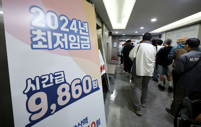 13일 서울의 한 고용복지플러스센터에 2024년 최저임금 입간판이 설치돼 있다. 연합뉴스