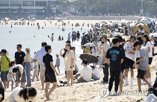 맑은 초여름 날씨를 보인 19일 오후 부산 해운대구 해운대해수욕장을 찾은 시민들이 더위를 식히고 있다. 연합뉴스