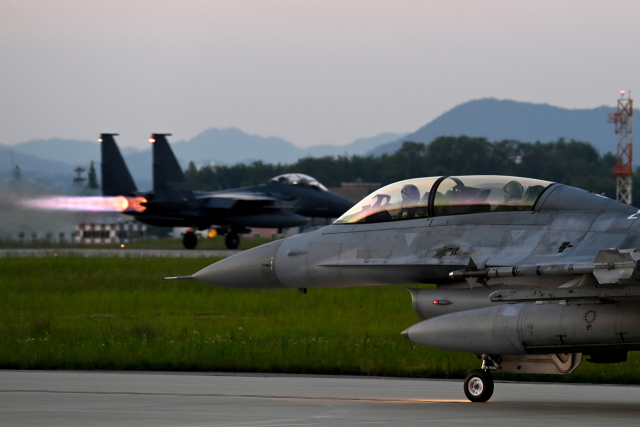 야간 출격을 위해 지상에서 이동하고 있는 공군 주력 기종인 F-16과 그 뒤로 이륙하기 위해 활주 중인 F-15K. 사진 제공=공군