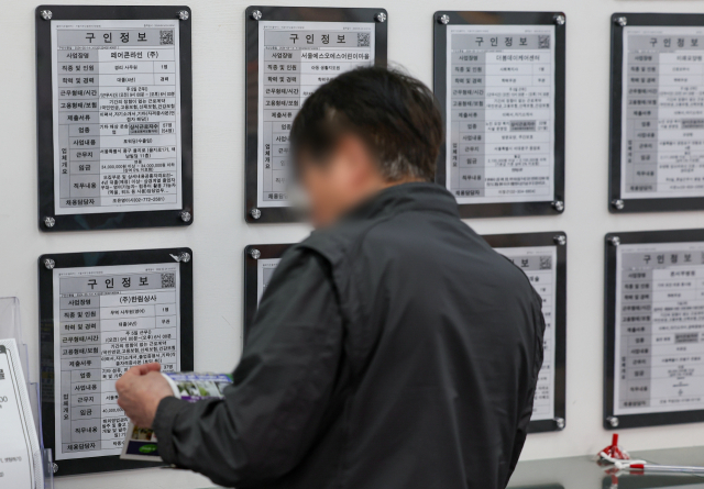 한 시민이 17일 서울의 한 고용센터에 마련된 일자리 정보 게시판을 살피고 있다. 연합뉴스.