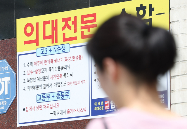 27년 만의 의대 입학정원 증원이 확정된 24일 서울 시내 한 학원 건물에 의대 입시 홍보물이 붙어 있다. 한국대학교육협의회는 이날 대입전형위원회를 열고 각 대학이 제출한 2025학년도 대입전형 시행계획 변경 사항을 심의·확정했다. 연합뉴스