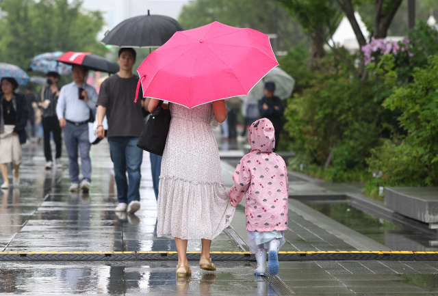 26일 오후 비가 내리는 서울 광화문광장에서 시민들이 우산을 쓴 채 걸어가고 있다.연합뉴스