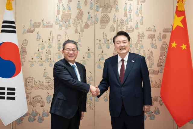 윤석열 대통령이 26일 서울 용산 대통령실 청사에서 리창 중국 국무원 총리와 악수하고 있다. 연합뉴스