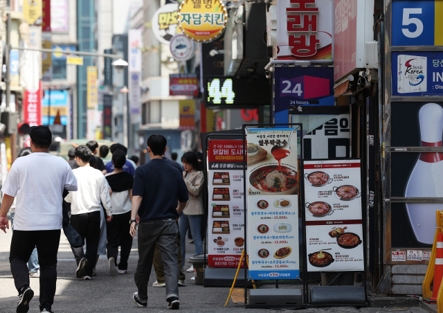 이달 23일 서울시내의 한 음식 거리를 행인들이 오가고 있다. 연합뉴스