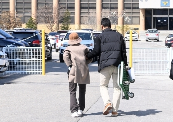 강릉에서 차량 급발진 의심 사고로 12살 손자를 잃고, 교통사고처리 특례법상 치사 혐의로 입건된 60대 할머니가 첫 경찰조사를 마치고 아들의 부축을 받으며 경찰서를 떠나고 있다. 연합뉴스