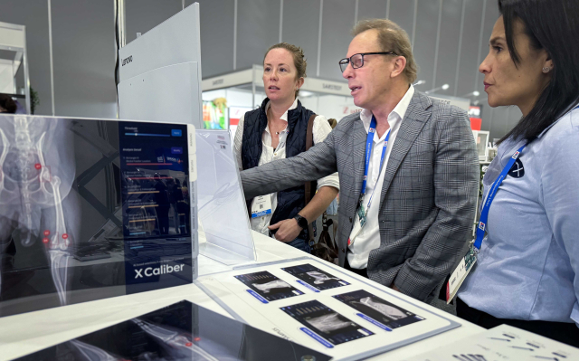 ATX의 로저 데이비스 대표(사진 가운데)가 28일 호주 최대 수의학회 행사인 AVA 컨퍼런스에서 참가 수의사에게 엑스칼리버를 소개하고 있다. 사진 제공=SKT