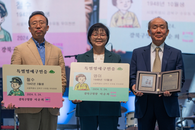 지난 24일 특별명예구민증을 전달받은 김주영 씨(오른쪽)와 김 씨 아들이 이순희(가운데) 강북구청장과 기념촬영을 하고 있다. 사진제공=강북구