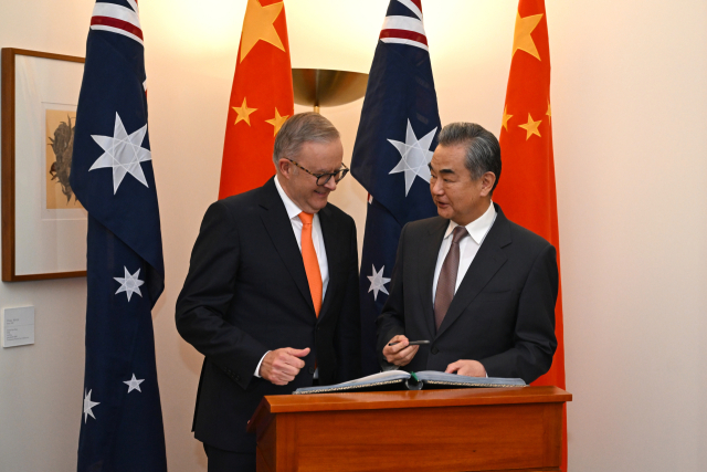 호주 캔버라에서 열린 회의에서 왕이(오른쪽) 중국 외교부장이 방명록에 서명하는 모습을 앤서니 알바니즈 호주 총리가 지켜보고 있다. EPA연합뉴스