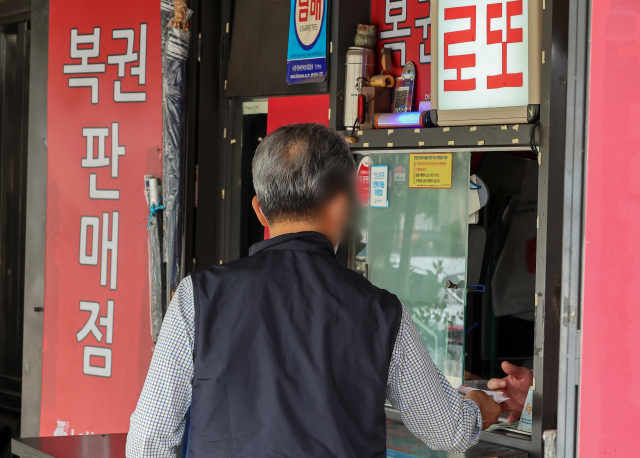 30일 서울 시내의 한 복권 판매점에서 시민이 복권을 구매하고 있다. 연합뉴스