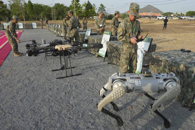 지난 16일 캄보디아 프놈펜 인근 한 마을에서 중국 인민해방군 소속 병사들이 로봇 개에 장착된 기관총을 시험하고 있다. AP연합뉴스
