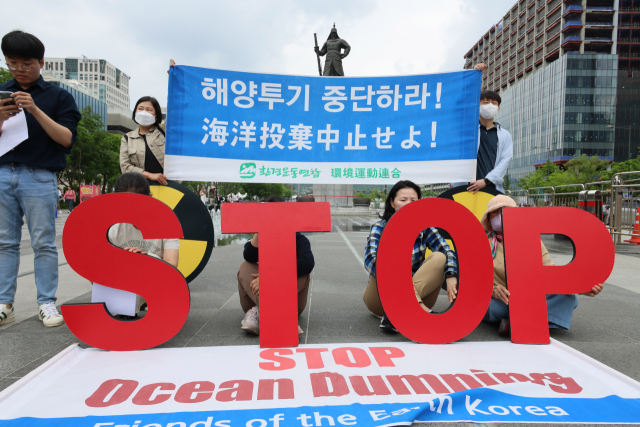 환경보건시민센터 관계자들이 20일 서울 광화문광장 이순신장군 동상 앞에서 제6차 일본 후쿠시마 해양투기 강행 규탄 기자회견을 하고 있다. 연합뉴스