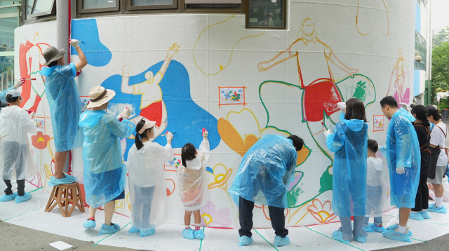 한국타이어앤테크놀로지 임직원과 가족들이 지난 1일 대전 신탄진 초등학교를 찾아 벽화 그리기 봉사활동을 하고 있다. 사진제공=한국타이어앤테크놀로지