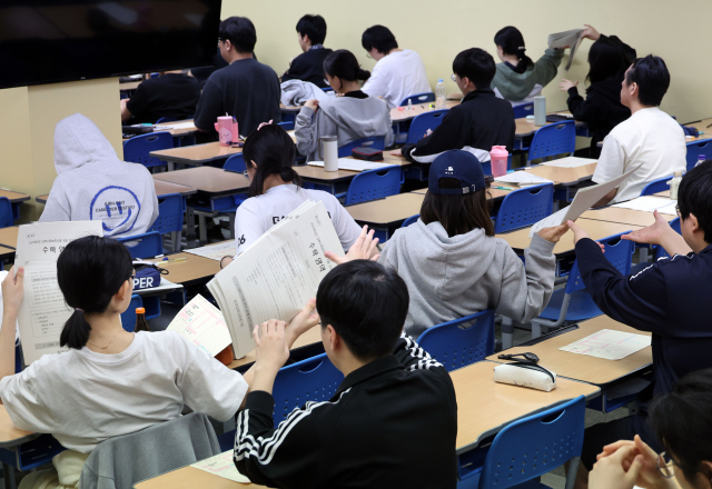 4일 오전 서울 양천구 목동종로학원에서 수험생들이 2025학년도 대학수학능력시험 평가원 6월 모의고사를 위해 시험지를 건네받고 있다. 연합뉴스