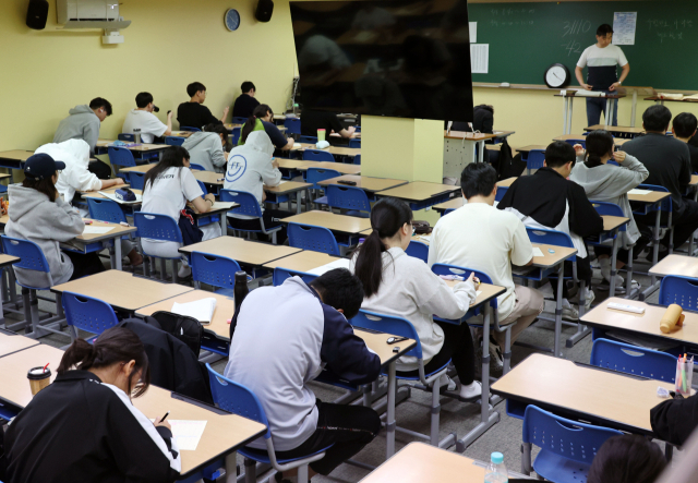 4일 오전 서울 양천구 목동종로학원에서 수험생들이 2025학년도 대학수학능력시험 평가원 6월 모의고사를 위해 시험지를 건네받고 있다. 연합뉴스