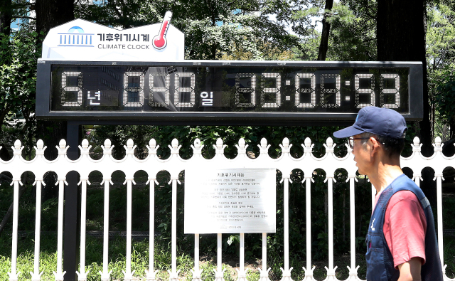 4일 서울 여의도 국회 앞에서 한 시민이 기후위기시계를 바라보고 있다. 사진=뉴스1