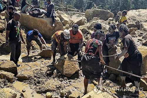 지난달 30일 파푸아뉴기니 엥가주 주민들이 산사태 현장에서 손으로 잔해들을 치우고 있다. AFP 연합뉴스