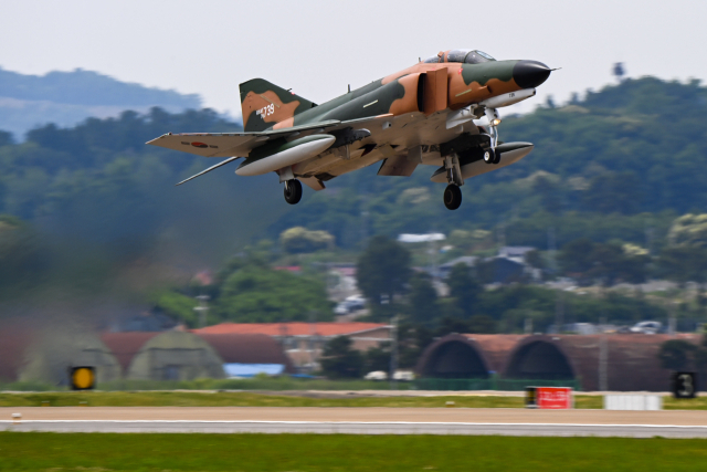 공군의 F-4E 팬텀 전투기가 7일 수원기지에서 거행된 ‘F-4 팬텀 퇴역식’에서 신원식 국방부장관의 출격명령을 받고 마지막 비행임무를 위해 힘차게 이륙하고 있다. 팬텀 퇴역의 역사적 의미를 되새기기 위해 이날 비행하는 F-4E 중 1대를 한국 공군 팬텀의 과거모습인 정글무늬(Jungle Camouflage Pattern)로 복원했다. 사진 제공=공군