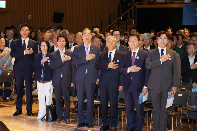 한덕수(가운데) 국무총리가 10일 서울시청에서 열린 제37주년 6·10민주항쟁 기념식에서 국기에 대한 경례를 하고 있다. 연합뉴스