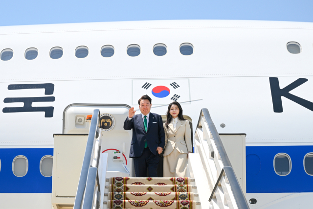 윤석열 대통령과 김건희 여사가 10일 오후(현지시간) 투르크메니스탄 아시가바트 공항에 도착해 전용기이 공군 1호기에서 내리며 인사하고 있다. 아시가바트=연합뉴스