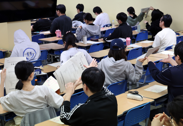 이달 4일 오전 서울 양천구 목동종로학원에서 수험생들이 2025학년도 대학수학능력시험 평가원 6월 모의고사를 위해 시험지를 건네받고 있다. 연합뉴스