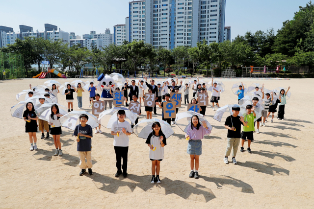 광주신세계는 12일 광주 서구 상무초등학교에서 김이강 서구청장, 이동훈 대표이사, 조명숙 상무초등학교 교장, 김재춘 초록우산 광주가정위탁지원센터장, 임직원들이 참여한 가운데 ‘환생우산’ 전달식을 진행했다. 사진 제공=광주신세계