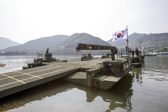 자주도하장비 ‘수룡’이 자체 내장된 크레인을 이용하여 부교를 구축하고 있다. 사진 제공=육군