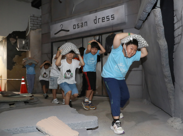초등학생들이 12일 경기 오산시 경기도국민안전체험관에서 지진 발생 시 대피 요령을 배우고 있다. 뉴스1