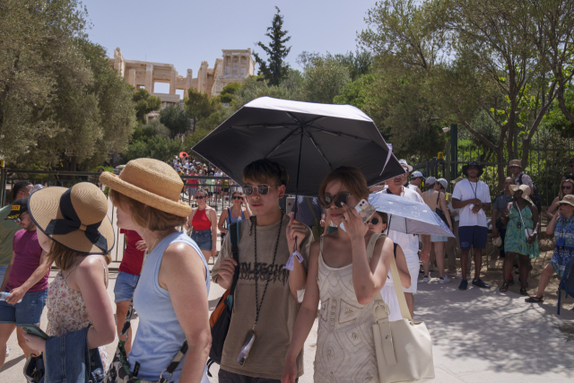 올 여름 세계 각국에서 폭염이 예상되는 가운데 그리스 관광지를 찾은 여행객들이 연신 땀을 닦아내고 있다. AP연합뉴스