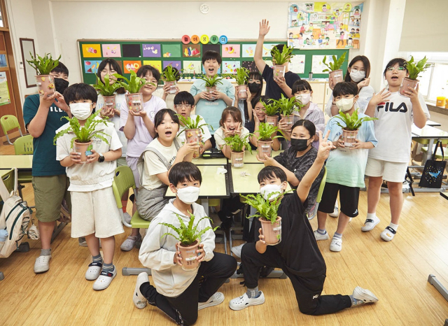 ‘교원 교실숲’ 7호가 조성된 양목초등학교 학생들이 단체 사진을 찍고 있다. 사진 제공=교원그룹