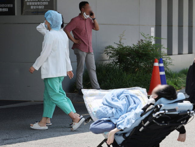 14일 서울 종로구 서울대병원에서 의료진이 한 소아환자 근처를 지나고 있다. 연합뉴스
