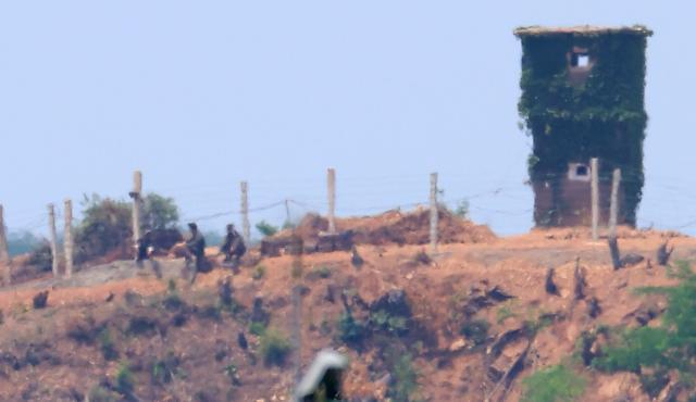 지난 9일 경기도 파주 접경지역에서 바라본 북한군 초소에서 북한군 병사들이 작업을 하다 잠시 휴식을 취하고 있다. 연합뉴