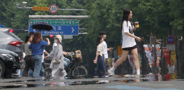 더위가 계속된 14일 대구 중구 공평네거리에서 시민들이 아지랑이가 피어오르는 도로 위를 지나가고 있다.연합뉴스