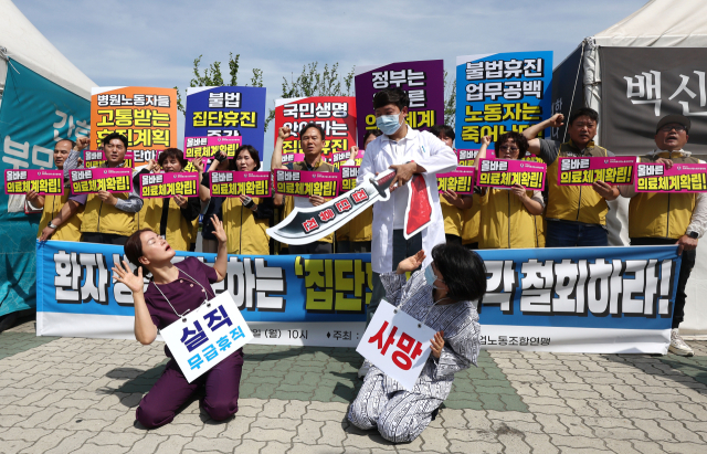 전국의료산업노동조합연맹 관계자들이 17일 서울 국회의사당 앞에서 열린 기자회견 도중 의료계의 집단 휴진 철회를 촉구하며 퍼포먼스를 하고 있다. 연합뉴스